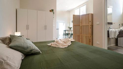a bedroom with a bed with a green blanket on it at Casa del Falegname - Loft Abete con cucina in San Giovanni in Bosco