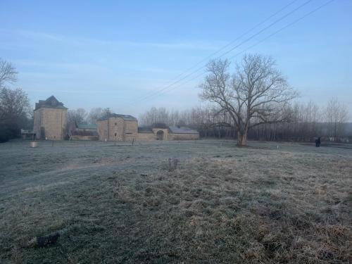 an empty field with a building in the background at Ferme de la Petite Forge in Couvin