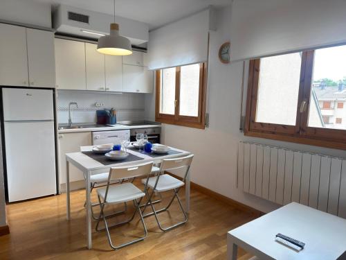 a kitchen with a table and chairs and a refrigerator at Alameda in Jaca