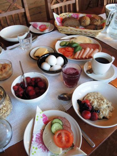 un tavolo di legno con piatti di cibo sopra di Tuukkalan Tila B&B a Ristiina