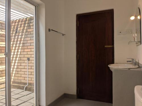 a bathroom with a sink and a sliding glass door at Seth Villa Matara in Matara