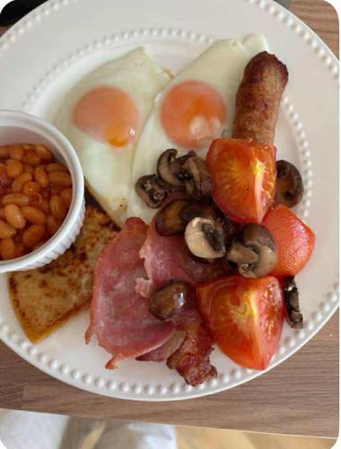 a plate of breakfast food with eggs bacon mushrooms and tomatoes at 4 Glenfalloch Road in Crianlarich