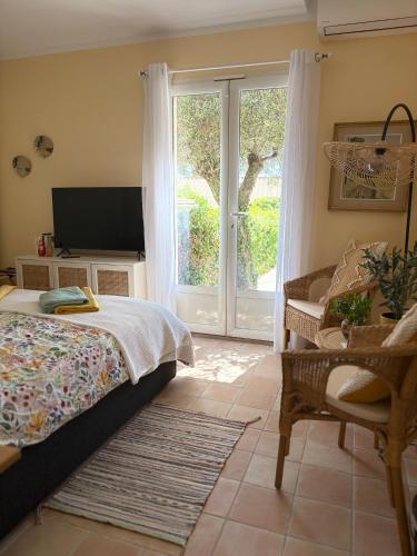 a bedroom with a bed and a tv and a window at Pitch Provence B&B in Ollioules