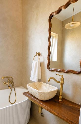a bathroom with a stone sink and a mirror at Villa Olivia in Banjole