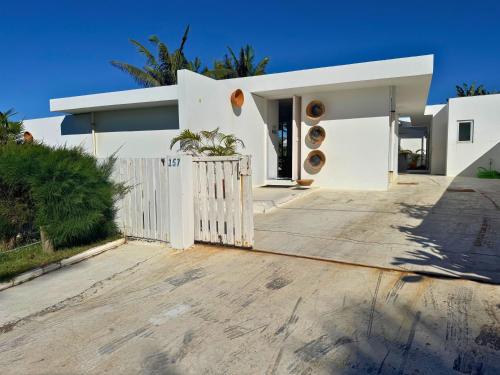 a white house with a white fence at Surfers Spot in Ponta do Ouro
