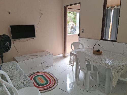 a white dining room with a table and chairs at Casa próximo a praia in Salvaterra
