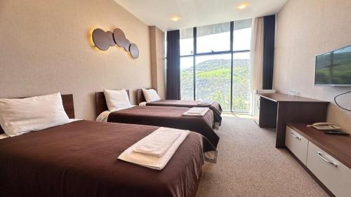 a hotel room with two beds and a large window at Arena Hotel Yardimli in Kabakhdibi