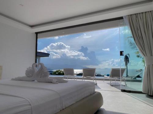 a bedroom with a bed with a view of the ocean at Villa Bardi - Breathtaking Sea View in Plai Laem