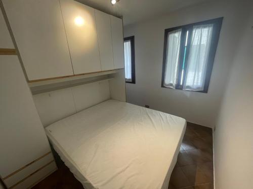 a small room with a bed and a window at Calle del Palazzo 12 in Grado