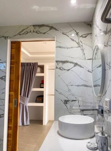 a bathroom with a sink and a mirror on a wall at Villa Bardi - Breathtaking Sea View in Plai Laem