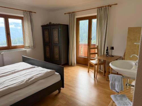 a bedroom with a bed and a sink and a tub at Ferienhaus Riedberg in Ried im Zillertal