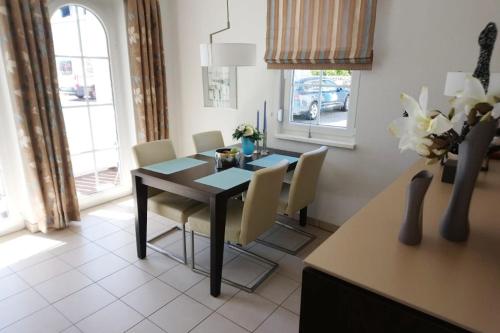 a dining room with a black table and chairs at Ferienwohnung Gesine 2 in Nienhagen