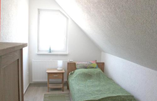 a small bedroom with a bed and a window at Jonas in Rerik