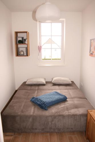 a large bed in a room with a window at Gesine 3 in Nienhagen