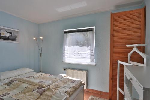 a bedroom with a bed and a window at Bungalow Alex in Börgerende-Rethwisch