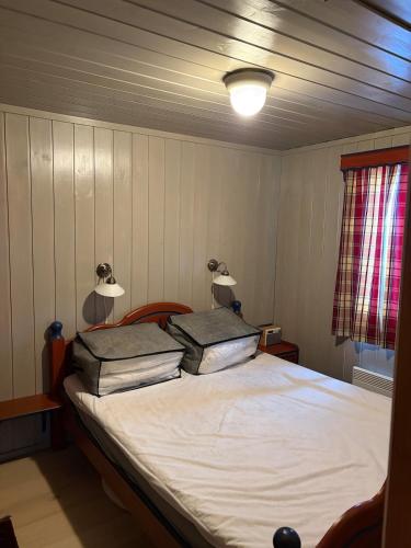 a bedroom with a bed with two pillows on it at Bakkestølveien 360 in Hol