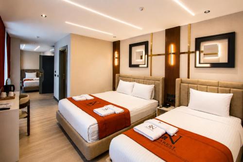 a hotel room with two beds and a bathroom at Nearest Airport Hotel in Arnavutköy