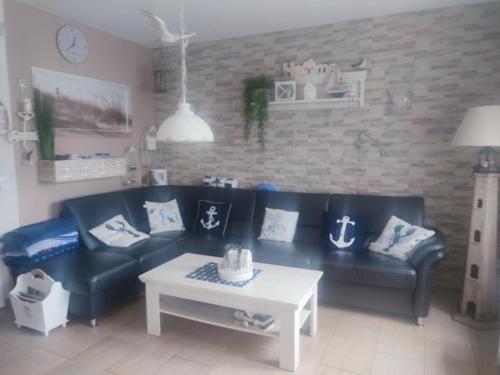 a living room with a black couch and a table at Fischers Fritze in Fehmarn