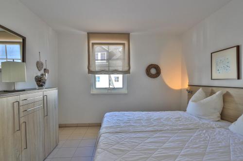 a white bedroom with a bed and two windows at Gesine 4 Mare Baltic in Nienhagen