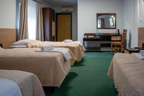 a hotel room with four beds and a mirror at Zielony Dworek in Kraśnik