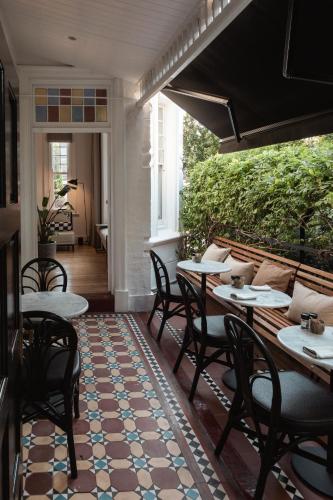 a porch with tables and chairs on a patio at âmé by NOAH in Cape Town