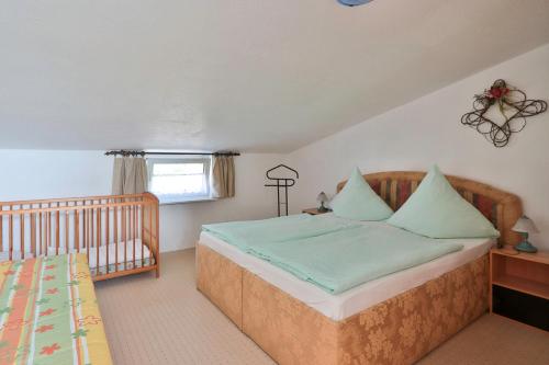 a bedroom with a bed and a crib in it at FeWo Geranie in Kröpelin