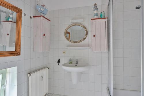 a bathroom with a sink and a mirror at Herrenhaus Blengow App.18 in Blengow