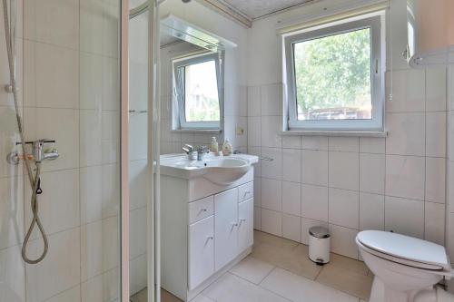a bathroom with a sink and a toilet and a window at FeWo Hibiskus in Kröpelin
