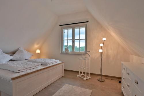 a bedroom with a bed and a window at FH Seeschwalbe in Niendorf