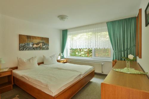 a bedroom with a bed and a window at Bungalow Koralle in Nienhagen