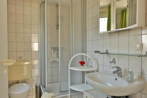 a bathroom with a sink and a shower and a toilet at Bungalow Koralle in Nienhagen