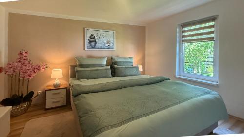a bedroom with a large bed and a window at Bungalow Konrad in Kühlungsborn