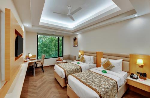 a hotel room with two beds and a window at Click collection Lucknow in Lucknow