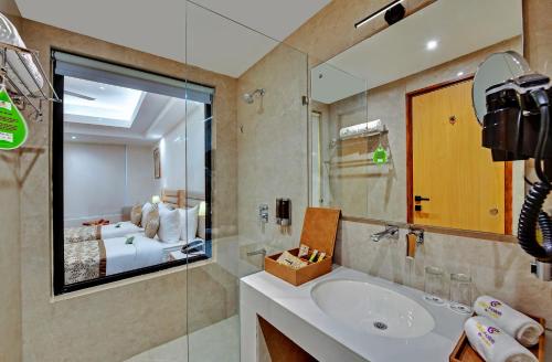 a bathroom with a sink and a mirror and a tub at Click collection Lucknow in Lucknow