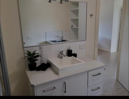 a bathroom with a white sink and a mirror at Executive Accommodation Bairnsdale in Bairnsdale