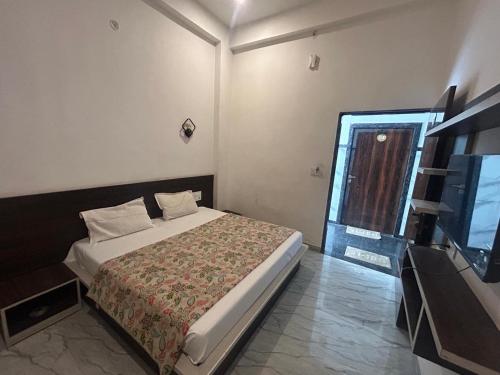 a bedroom with a bed and a television in it at Mahendra place in Khātu