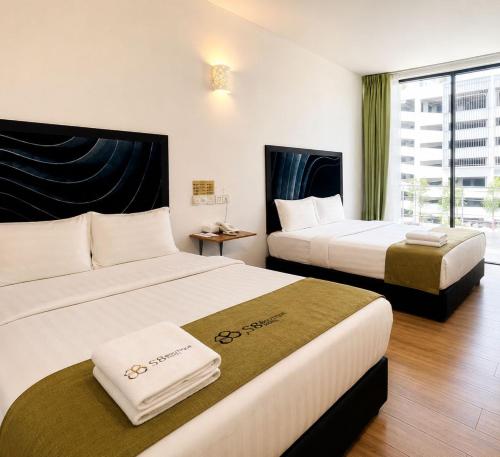 a hotel room with two beds and a window at S8 Boutique Hotel near KLIA 1 & KLIA 2 in Sepang