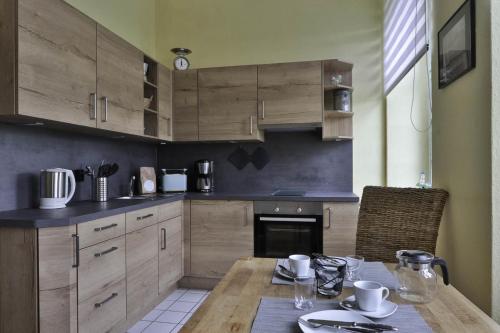 a kitchen with wooden cabinets and a wooden table at Herrenhaus Blengow App.03 in Blengow