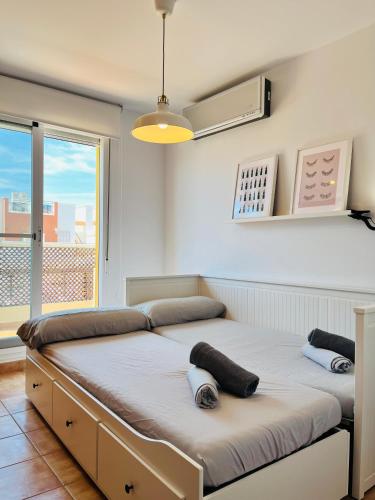 a bed in a room with a large window at Costa Norte in Alcalà de Xivert