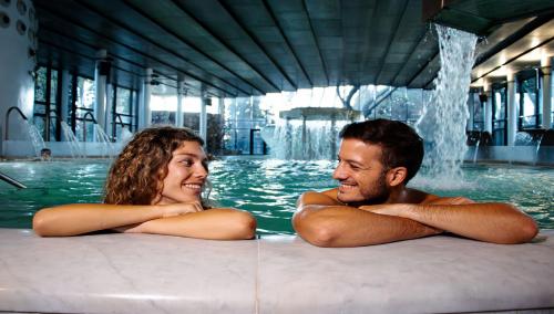 a man and a woman in a swimming pool at Termes Montbrio Hotel & Spa in Montbrió del Camp