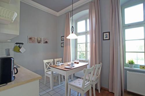 a kitchen with a table and chairs in a room at Herrenhaus Blengow App.02 in Blengow