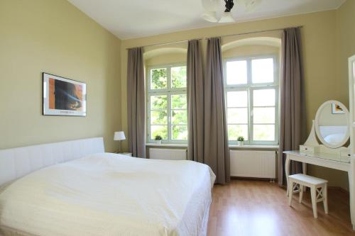 a bedroom with a white bed and a mirror at Herrenhaus Blengow App.02 in Blengow