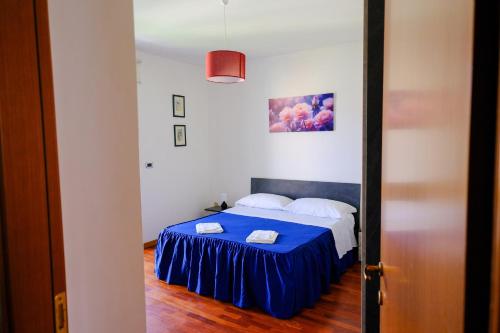 a bedroom with a bed with a blue bedspread at Renée Guest House in Paestum