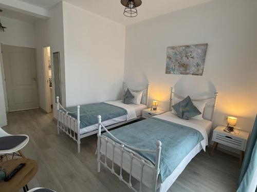 two beds in a room with two lamps at Tina Guest House in Basarabi