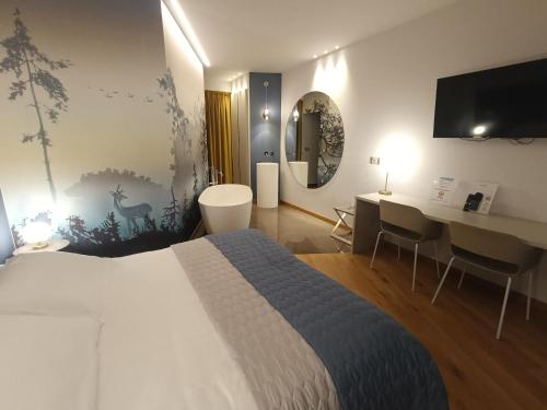 a hotel room with a bed and a desk with a computer at HOTEL - BAR DA NATALE in Paesana