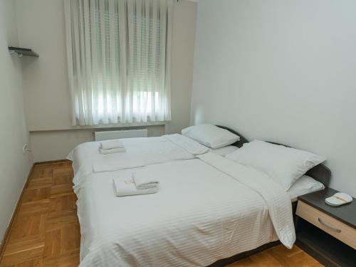 a white bed in a room with a window at Rondo Condos by TORO in Mostar