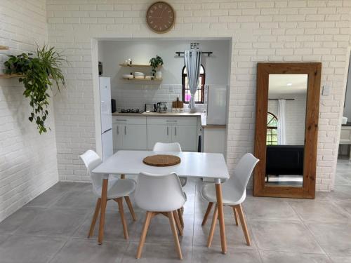 a kitchen with a white table and white chairs at 19 on Amber in Ugie