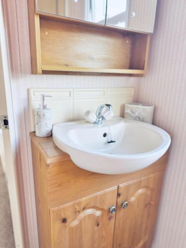 a bathroom with a sink and a mirror at 6 Birth Cosy caravan 134 Sealands in Ingoldmells