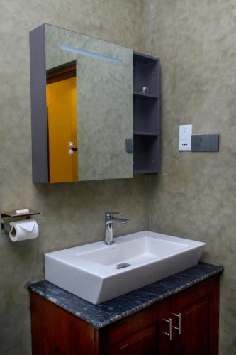 a white sink in a bathroom with a mirror at Madu River Reach in Balapitiya