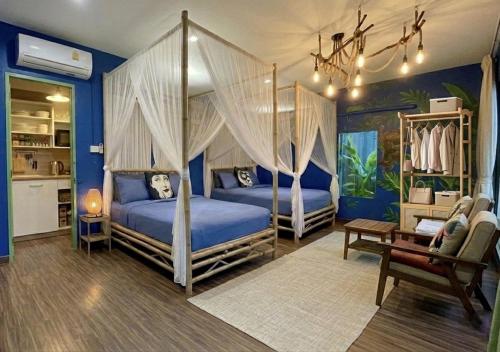 two beds in a bedroom with blue walls at Nego Home Ancient Inn in Bangkok